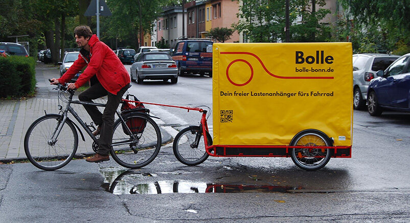 Radfahrer mit Lastenfahrrad und Anhänger