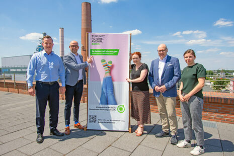 Gruppenbild mit einem Plakat zum Bonner Wärmeplan