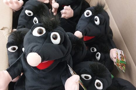 La foto muestra una caja abierta de la que asoman topos de peluche.