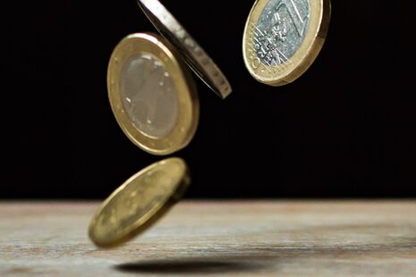 Monety euro spadają na "podłogę"/stół.